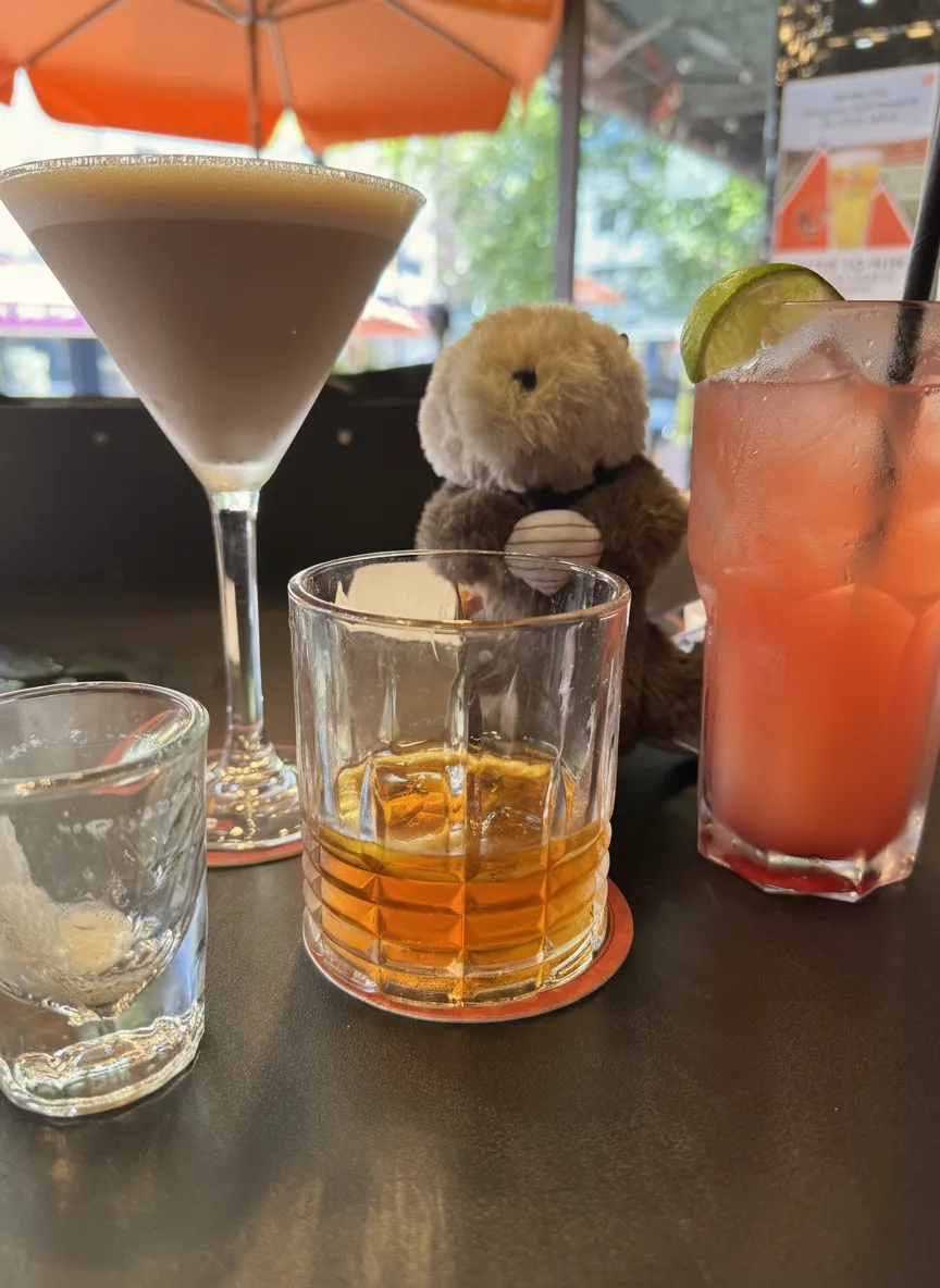 Three drinks and a plush toy on a table